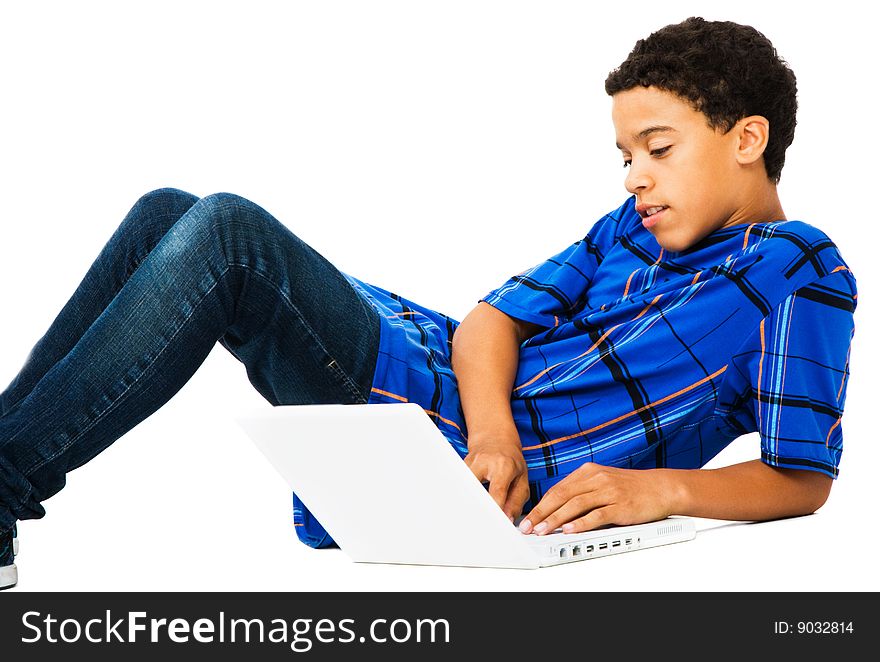 Teenage boy reclining on the floor and using a laptop isolated over white. Teenage boy reclining on the floor and using a laptop isolated over white