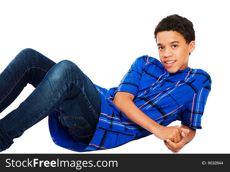 Teenage boy reclining on the floor isolated over white. Teenage boy reclining on the floor isolated over white