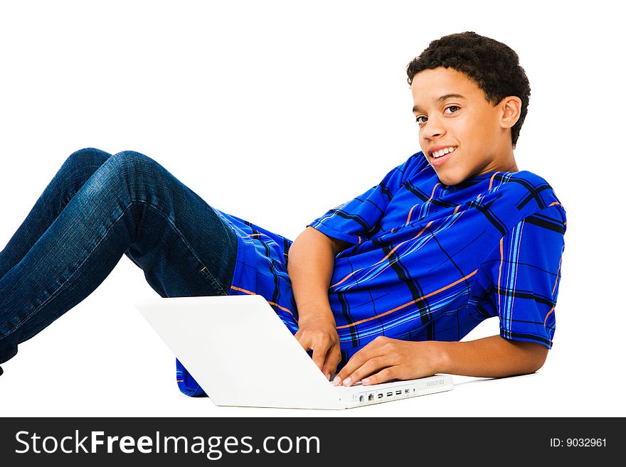 Teenage boy reclining and using a laptop isolated over white. Teenage boy reclining and using a laptop isolated over white