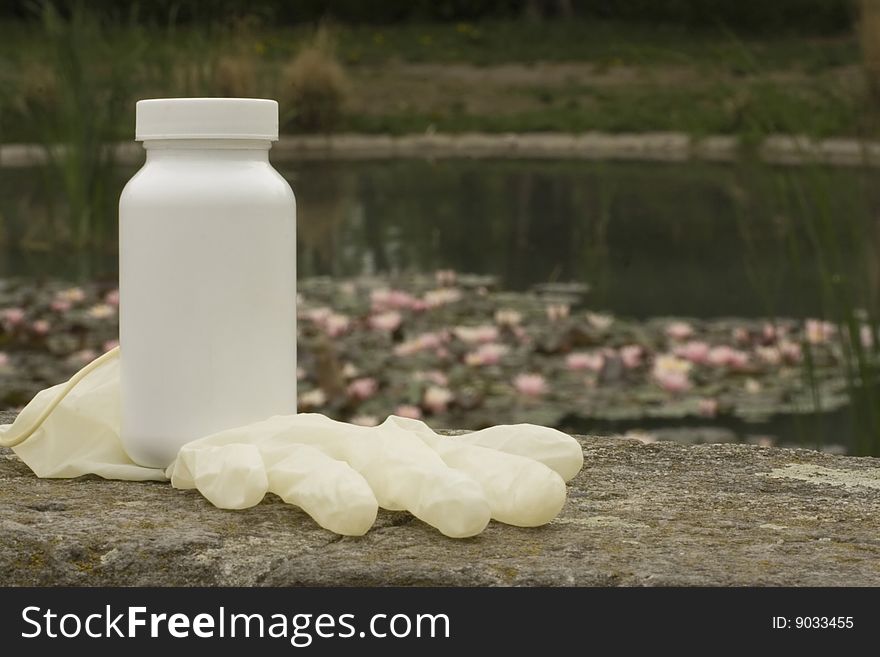 A white box on the rock. The white surface waiting for your product label. Water lily in the background.