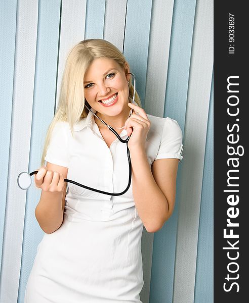 Portrait of a young beautiful doctor with a stethoscope in the office