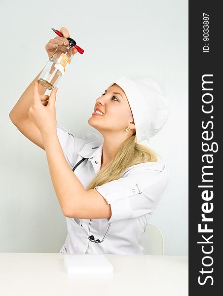 Portrait of a beautiful young doctor with a stethoscope and medications sitting by the table in her office