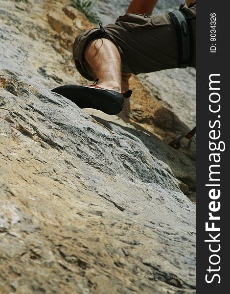 Calf of masculine climber on rock. Calf of masculine climber on rock