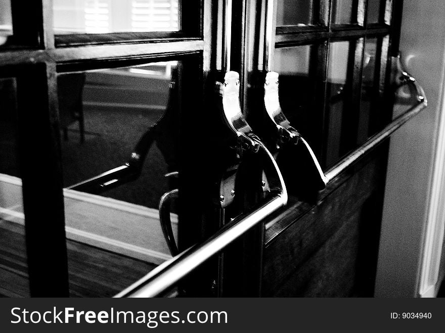 Closed door with long brass handles. Black and white. Closed door with long brass handles. Black and white.