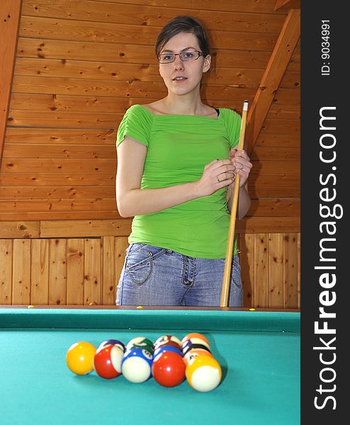 Young girl holding billard stick, ready to play a game. Young girl holding billard stick, ready to play a game