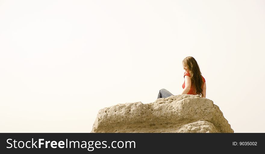 Girl sitting on a cliff