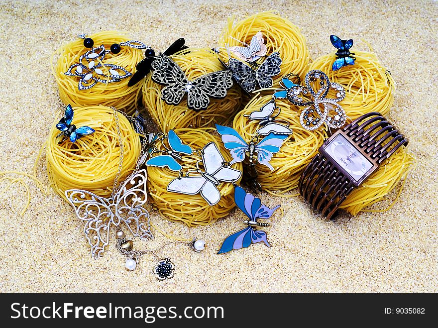 Luxury butterflies lie on spaghetti on the grain background