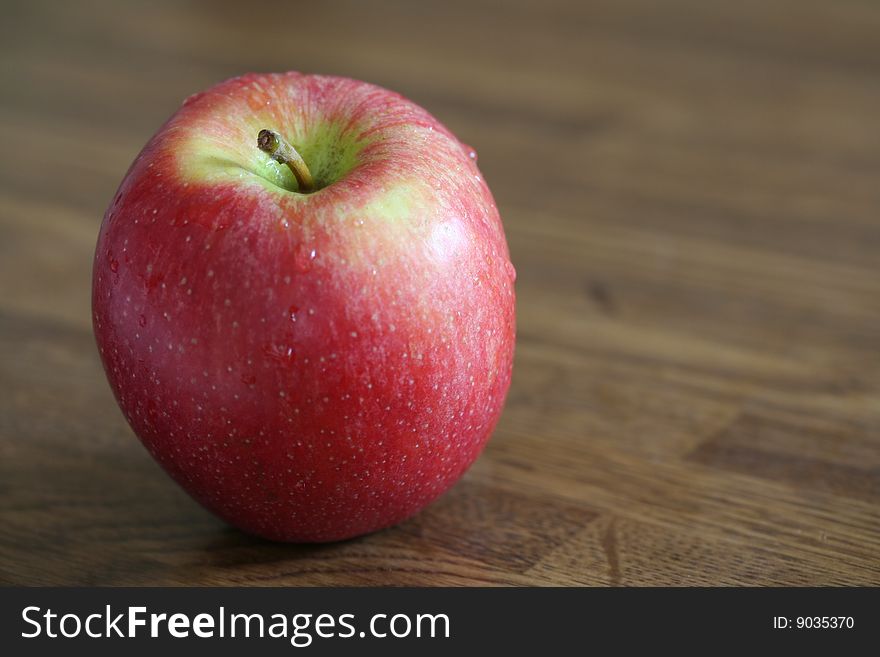 A red apple on a wooden surface