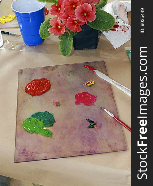 Coral primroses and an artists palette of paint. Coral primroses and an artists palette of paint.