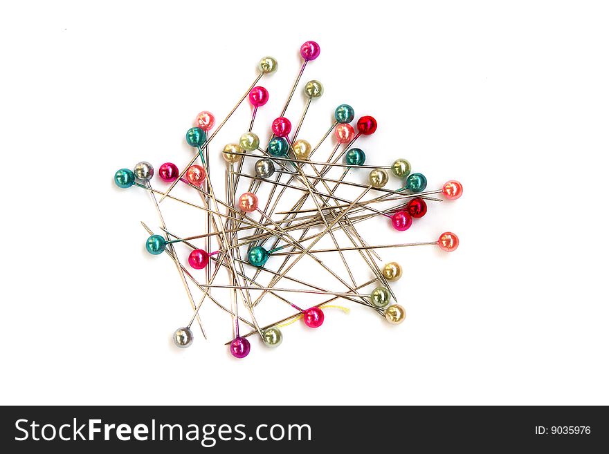 Heap of multi-coloured sewing pins on a white background