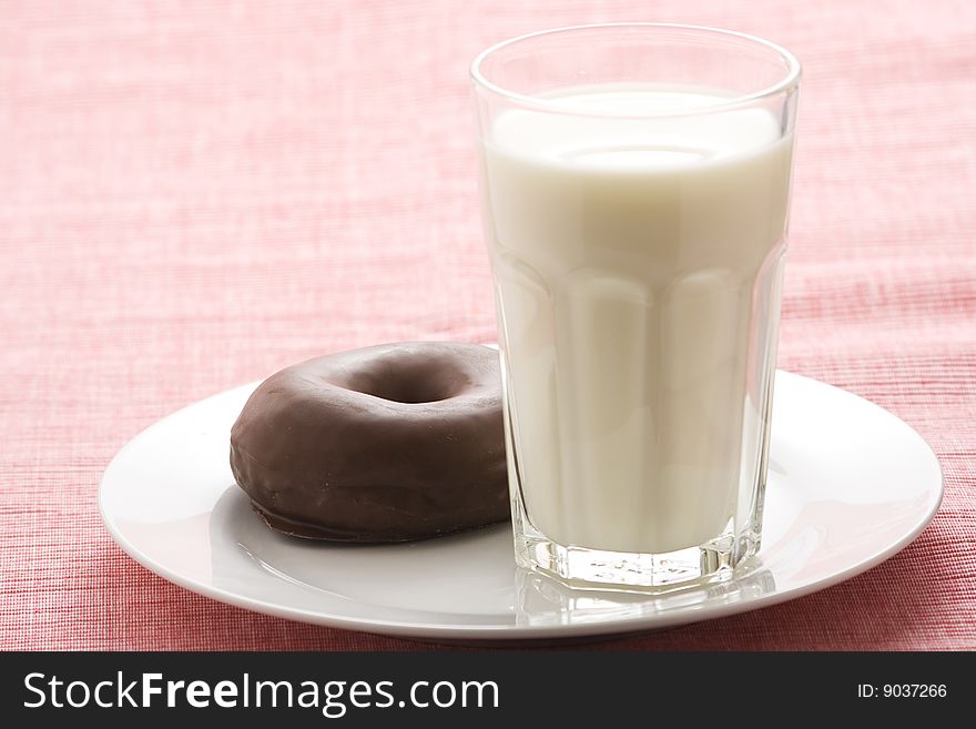 Breakfast glass of chocolate milk and donut isolated