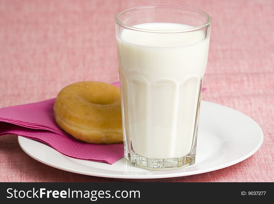 Breakfast glass of chocolate milk and donut isolated