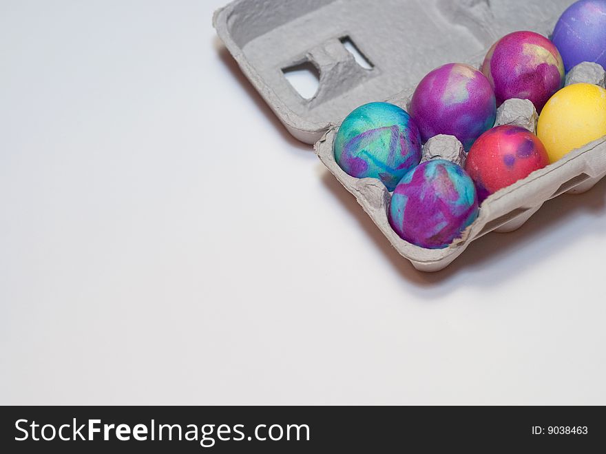 Six died Easter eggs in a cardboard carton isolated on white. Six died Easter eggs in a cardboard carton isolated on white