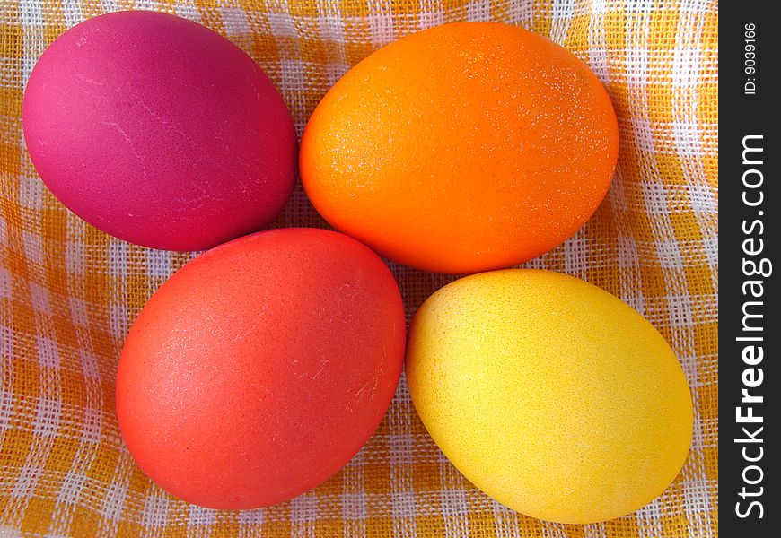Traditional color Easter eggs on yellow checkers tablecloth