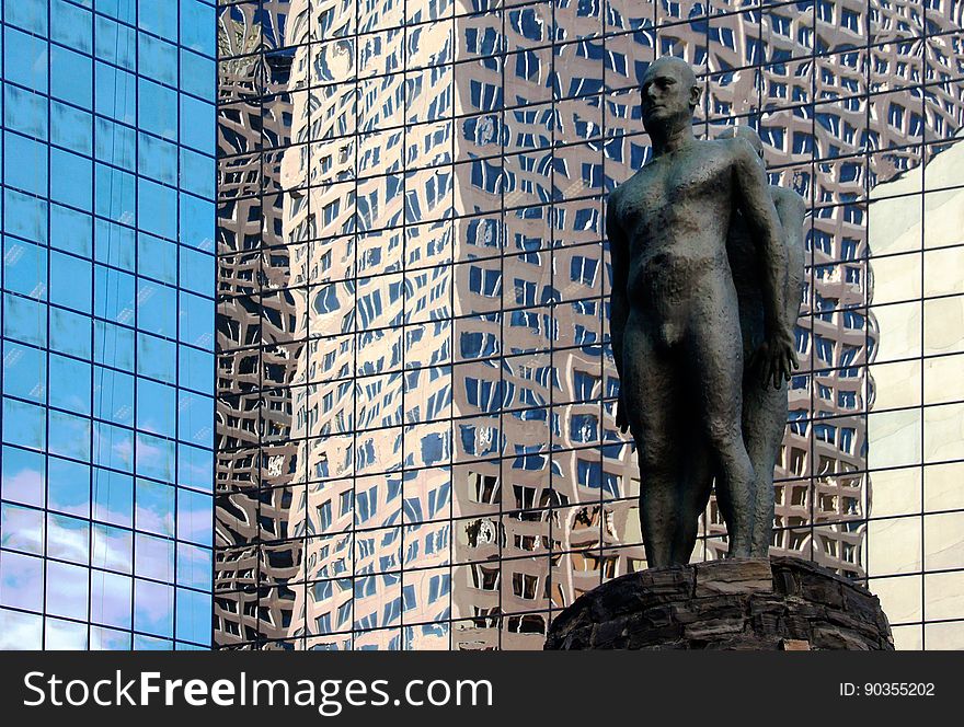 On the plaza is a mythic landscape: a cone of local rundle stone is a reference to the mountains; overscaled bronze ammonites a hidden landscape exposed. Standing on top, between earth and sky, are two bronze figures, back to back. Standing to the side, holding a fossil, is another figure – his gaze distracted by the view of the sky. On the plaza is a mythic landscape: a cone of local rundle stone is a reference to the mountains; overscaled bronze ammonites a hidden landscape exposed. Standing on top, between earth and sky, are two bronze figures, back to back. Standing to the side, holding a fossil, is another figure – his gaze distracted by the view of the sky.