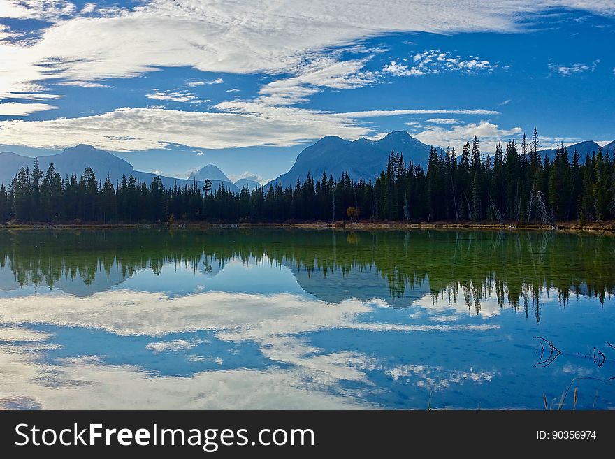 A lake reflecting forest, mountains and the sky. A lake reflecting forest, mountains and the sky.