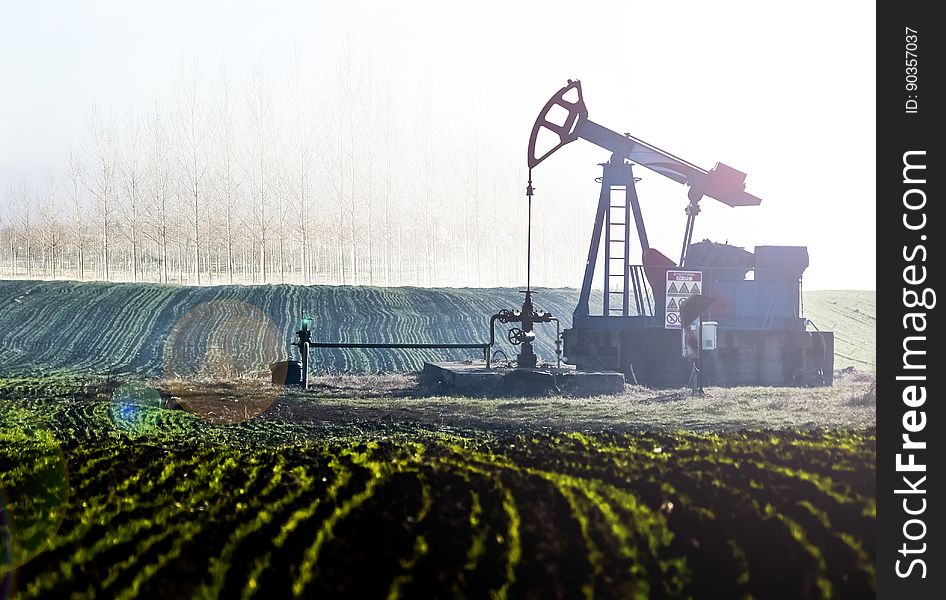 An oil pumpjack in the middle of a field. An oil pumpjack in the middle of a field.