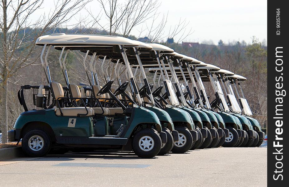 A row of golf carts parked on the street.