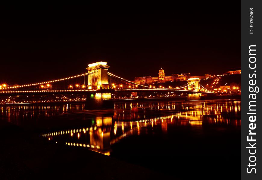 Illuminated Bridge Over River At Night