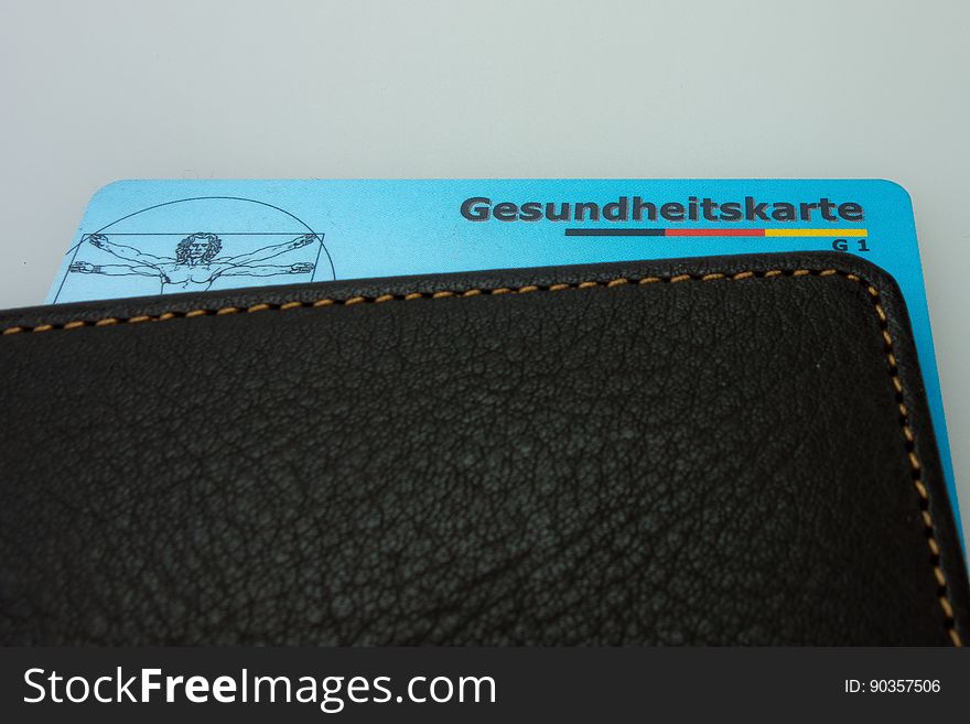 A health insurance business card sticking out of a leather wallet.