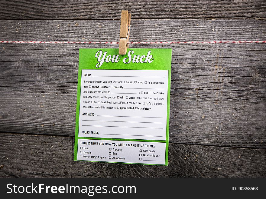 A "you suck" note on a wooden background.