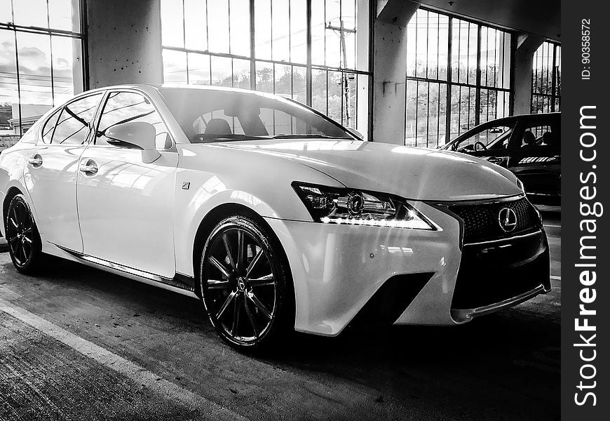 A black and white photo of a Lexus in a garage. A black and white photo of a Lexus in a garage.