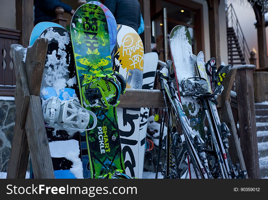 Snow boards and skis against the wall of a skiing lodge. Snow boards and skis against the wall of a skiing lodge.