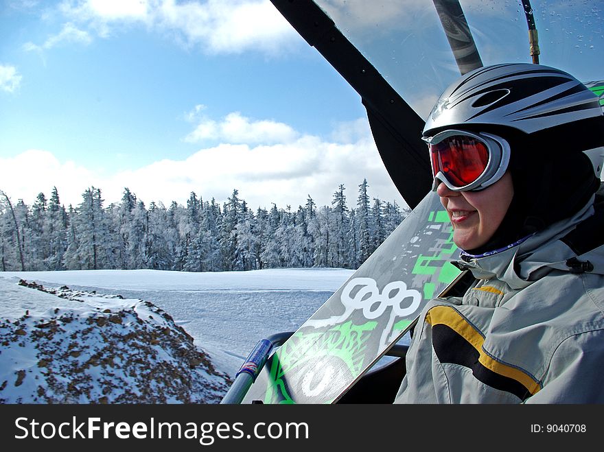 Snowboarder with her snowboard on chairlift