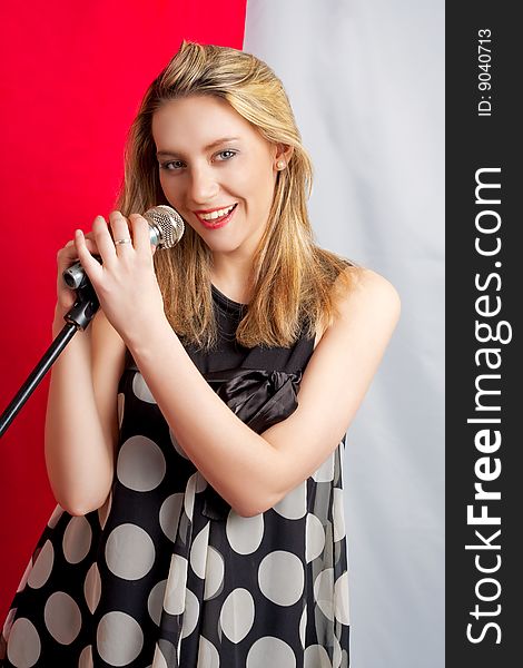 Young blonde girl with microphone smiling. Young blonde girl with microphone smiling