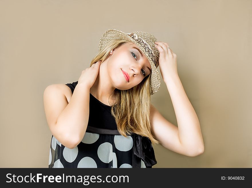 Blonde in straw hat smiling stag with hands lifted up