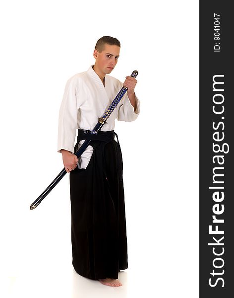 Young adult boy practicing the martial art of the samurai warriors, studio shot