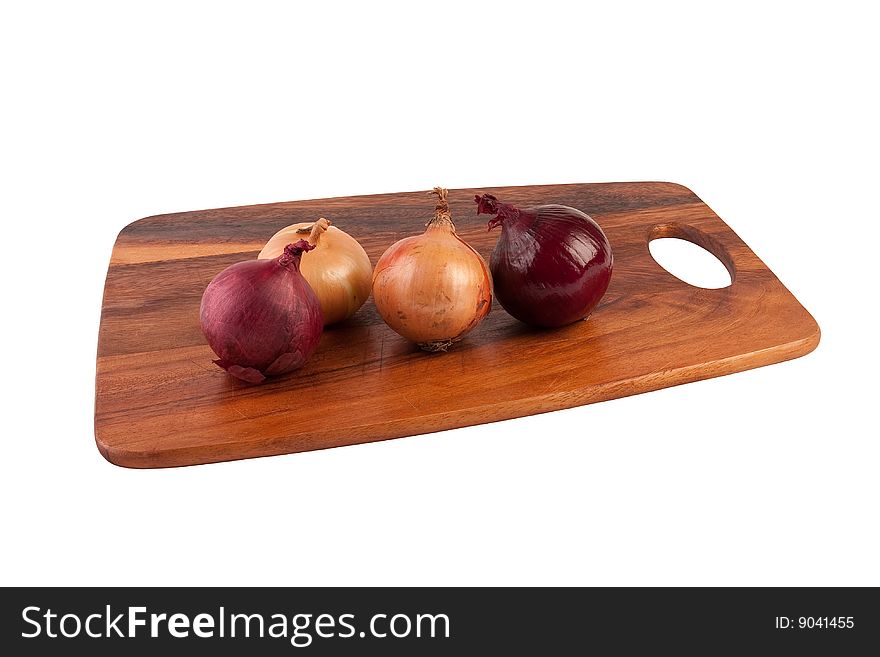 Two brown and two purple onions on brown cutting board. Isolated on white. Two brown and two purple onions on brown cutting board. Isolated on white.