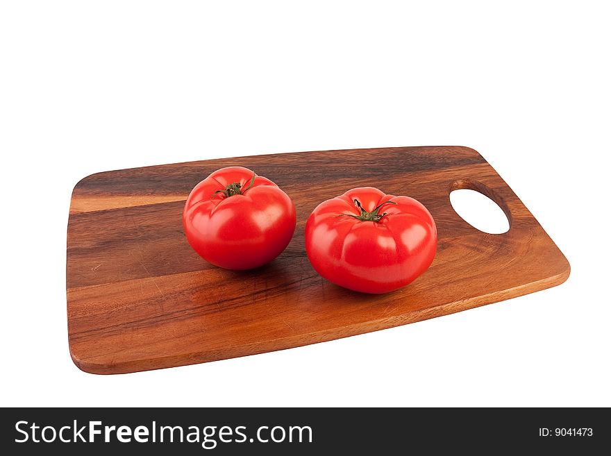 Two tomatoes on cutting board. Isolated on white.