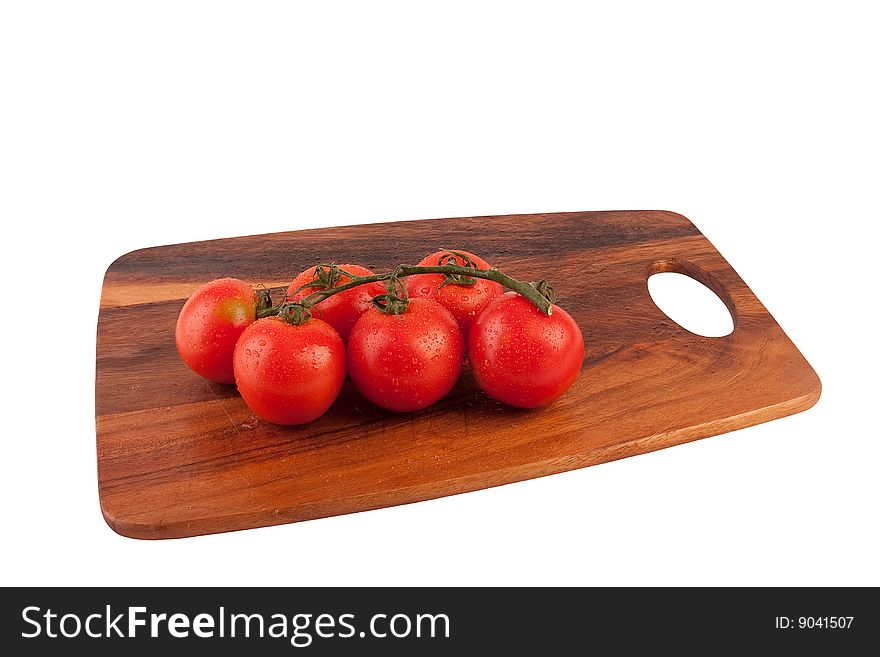 Bunch of red tomatoes on cutting board. Isolated on white. Bunch of red tomatoes on cutting board. Isolated on white.