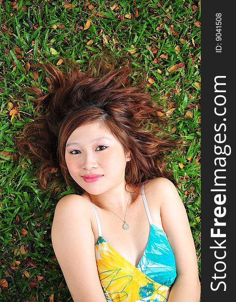 Beautiful Asian Woman Laying On The Grass In The Park. Beautiful Asian Woman Laying On The Grass In The Park.