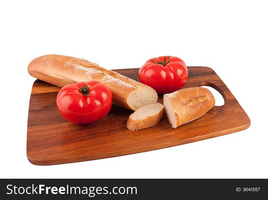 Two tomatoes and slices of baguette on cutting board. Isolated on white.