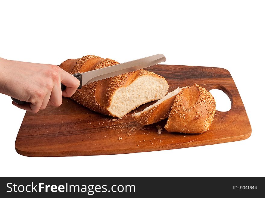 Hand cutting bread on cutting board. Isolated on white.