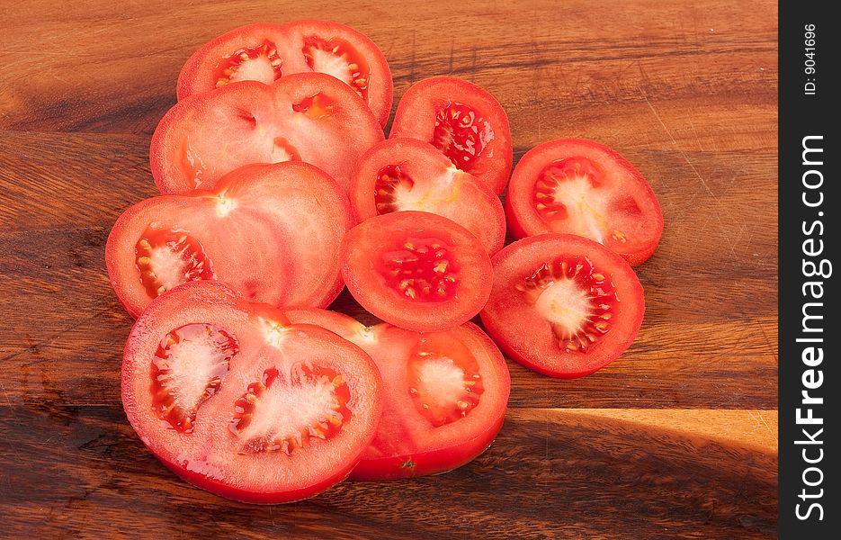 Sliced red and wet tomatoes on cutting board. Sliced red and wet tomatoes on cutting board.