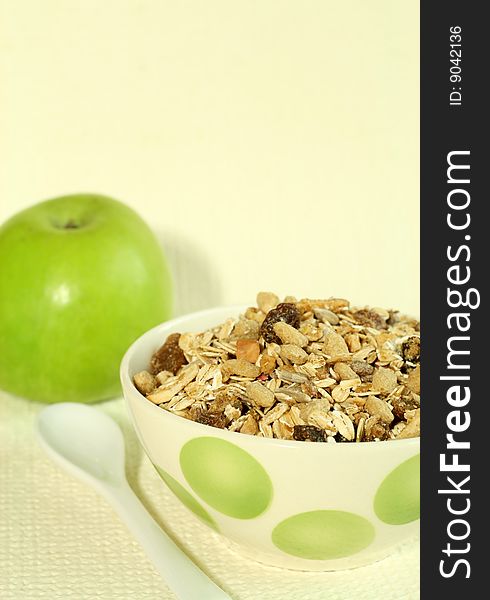 Muesli and green apple on beige background