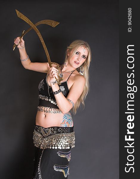 Beautiful Blond Belly Dancer with bronzed tribal swords