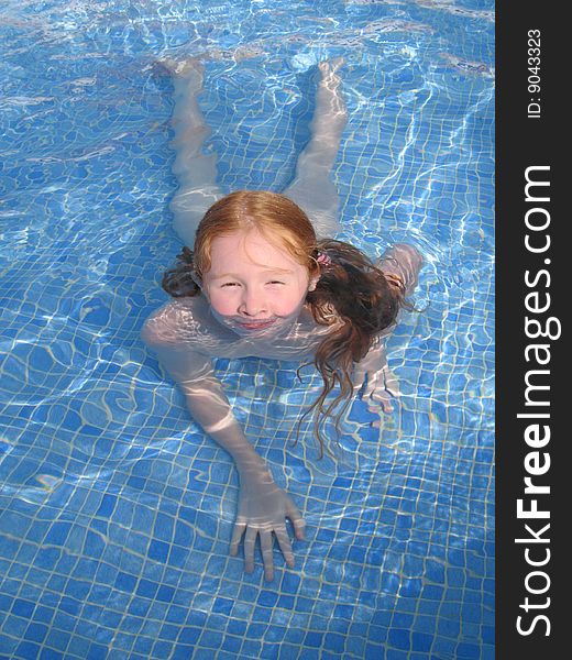 Young girl having fun bathing in a pool. Young girl having fun bathing in a pool.