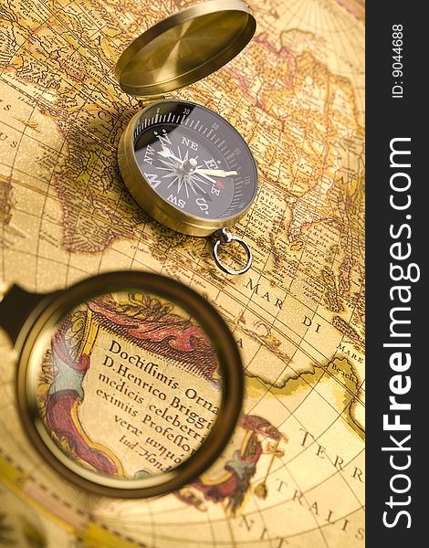 A beautiful golden compass and old magnifier. A beautiful golden compass and old magnifier