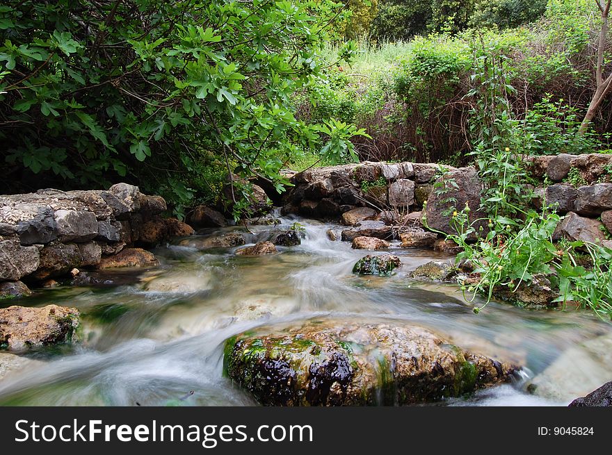 The flow of a river stream - long exposure. The flow of a river stream - long exposure