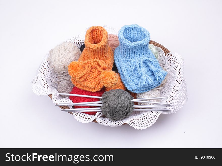 Close look on woollen baby shoes in a basket