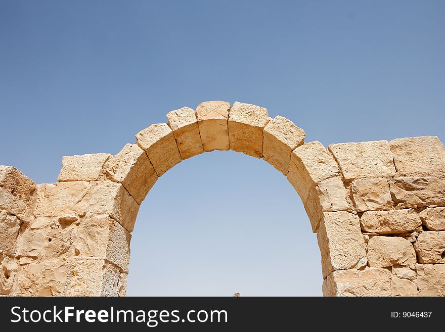 Ruins of ancient stone arch on sky background