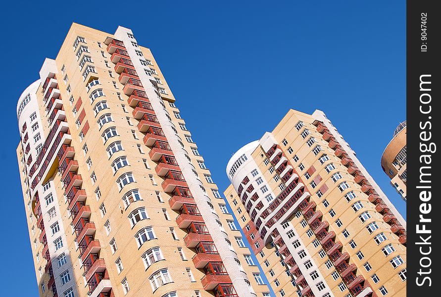 Modern tall residential building on a background of blue sky.