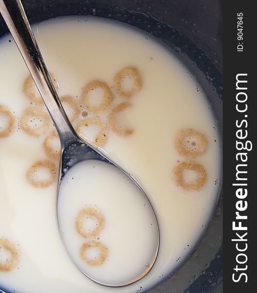 Close up of round oat cereal in a bowl with spoon. Close up of round oat cereal in a bowl with spoon.