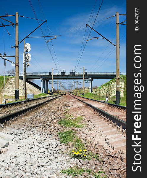 The railway passing through a green with the blue sky