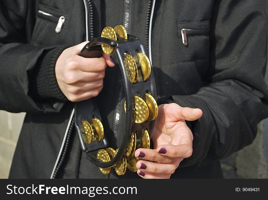 Street musician, womans hands keeps tambourine