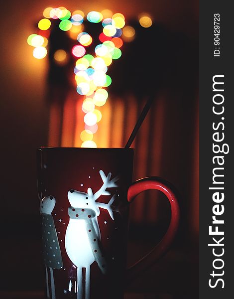 A close up of a Christmas cup with blurred lights.